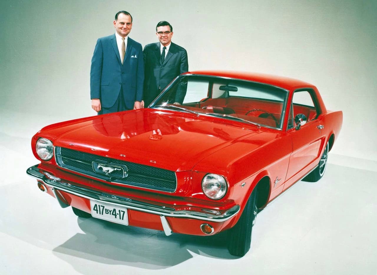 Para finales de 1963 ya el 
<b>diseño final</b> del Mustang estaba decidido y cerrado. En esta imagen vemos a Lee Iacocca (izquierda) líder del Grupo Fairlane y presidente de la división Ford Junto a Don Frey jefe de ingeniería de la Ford Motor Company. Iacocca y Frey son considerados como los padres del Mustang. La placa del auto en la foto que fue enviada a todos los concesionarios Ford del país, se lee 
<b>417 para 4-17</b>, queriendo decir que querían vender 417,000 unidades para el 17 de abril de 1965, al año del lanzamiento del carro. En ese momento nadie tenía idea del fenómenos de ventas que sería el Mustang. El modelo superó esa cifra con creces.