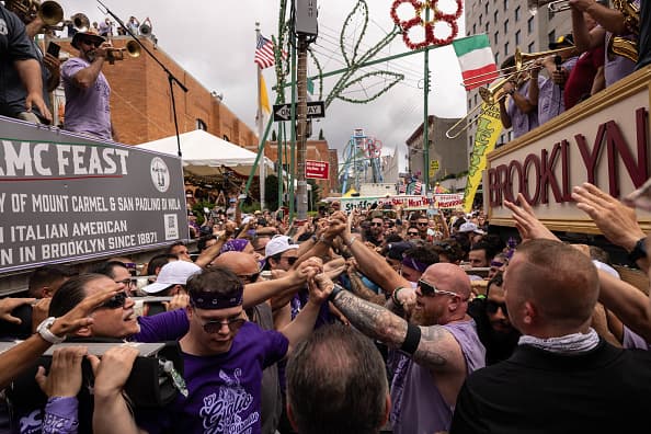 Los levantadores se dan la mano mientras cargan la torre Giglio.