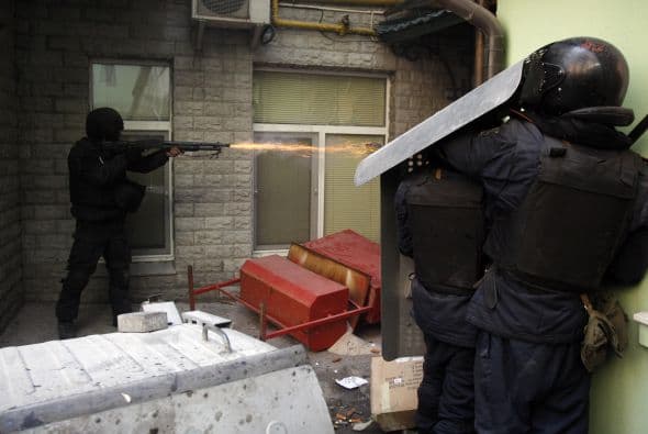 La policía ucraniana cercó hoy a los manifestantes en el corazón de las protestas opositoras de la plaza de la Independencia de Kiev (Maidán), tras una jornada en la que murieron 14 personas en los disturbios que estallaron en la capital. Víktor "Yanukóvich se ha convertido en un presidente sangriento", aseguró hoy el dirigente opositor Vitali Klitschkó en un llamamiento a los países democráticos para que intervengan en Ucrania y frenen la violenta confrontación. Según se acercaba la medianoche, los temidos Berkut, el destacamento antidisturbios, estrechaban el cerco en torno a los miles de manifestantes concentrados en el Euromaidán, bastión de las protestas desde el pasado 21 de noviembre. "Los extremistas de la oposición han cruzado la línea roja; matan a inocentes en la calles de la capital de Ucrania, vejan a mujeres, queman edificios y automóviles. Y si los disturbios continúan, nos veremos obligados a actuar con firmeza", rezaba el ultimátum del Servicio de Seguridad y el Ministerio del Interior de Ucrania. Advierten a los americanos que se queden dentro de las casas y de nuevo se sienten explosiones en la ciudad.