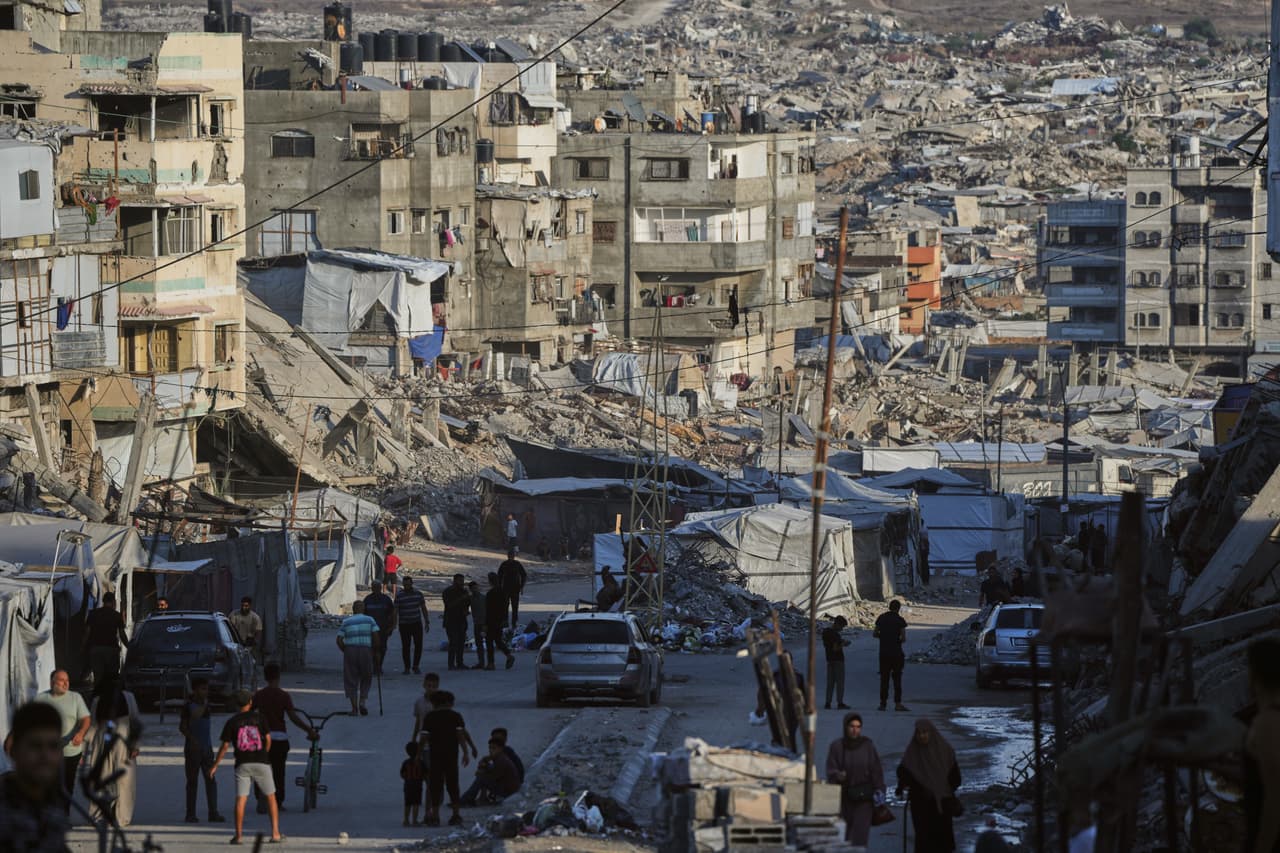 Unos palestinos caminan por una calle rodeada de edificios destruidos en ataques militares israelíes durante la guerra entre Israel y Hamás en la ciudad de Gaza, el martes 6 de octubre de 2026.