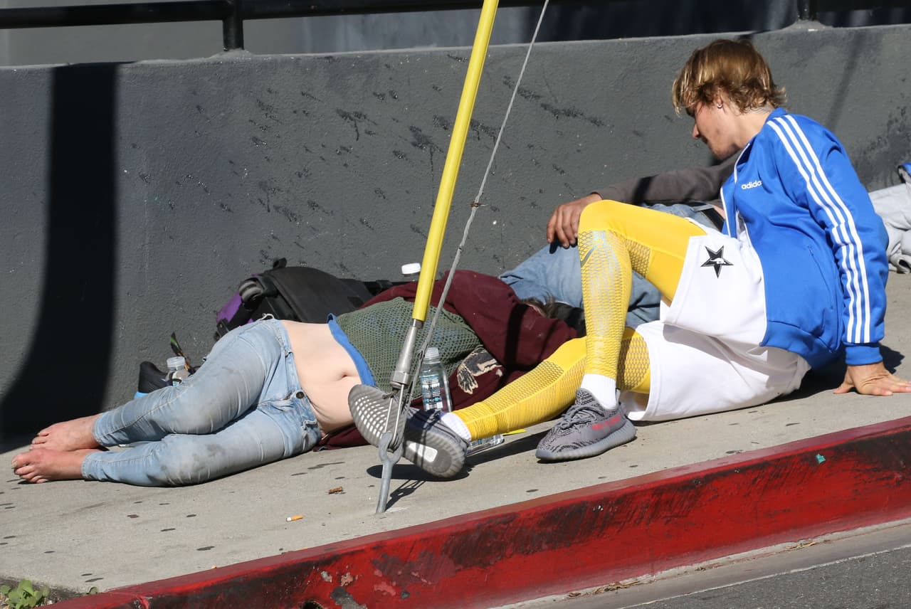 El intérprete de 'Love Yourself' se sentó a conversar con la mujer, mientras otros dos hombres se mantenían tumbados en el pavimento.