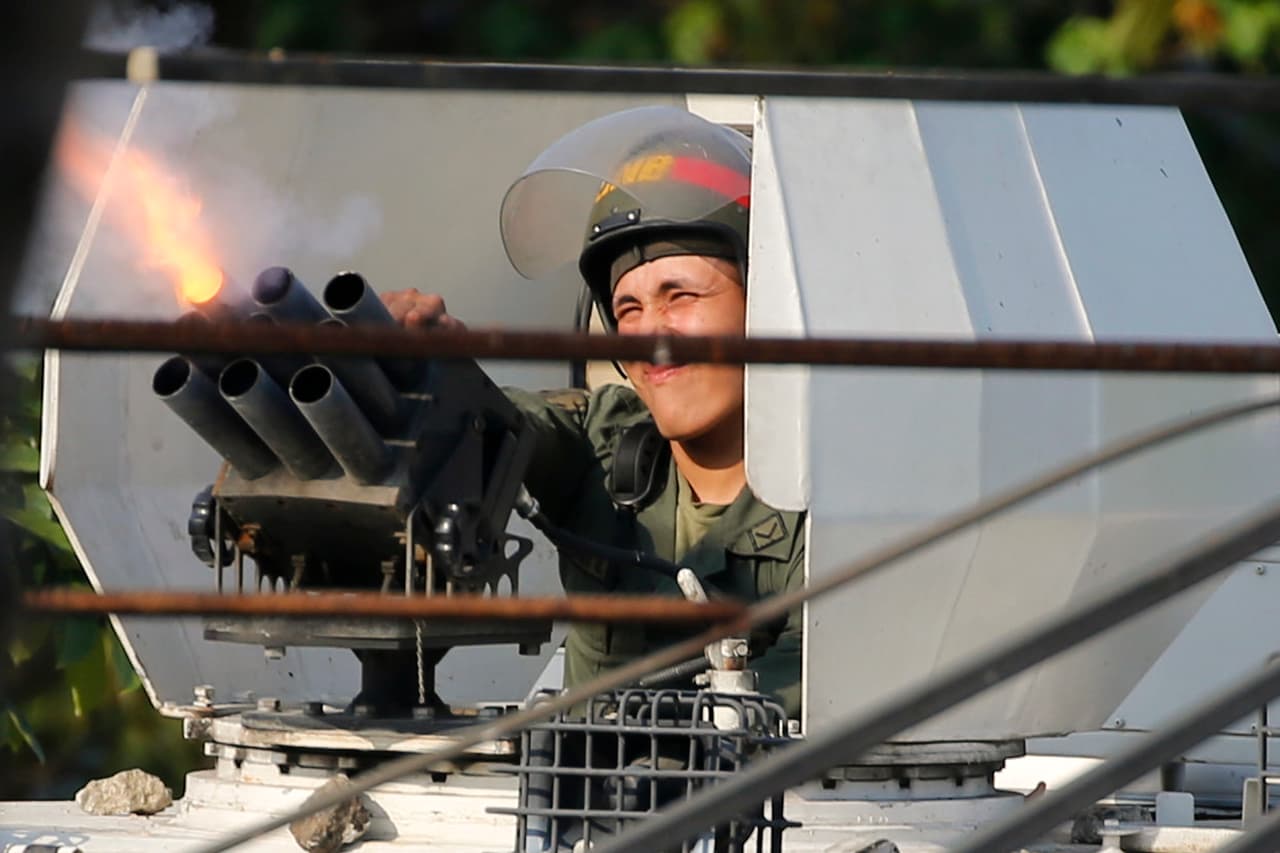 Un militar leal a Maduro dispara gases lacrimógenos a los manifestantes.
<br>