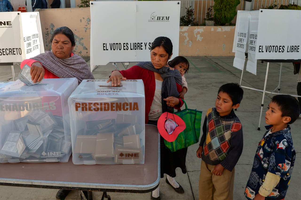 Una mujer ejerce el derecho al voto acompañada de sus hijos en Solapan, en el estado de México.