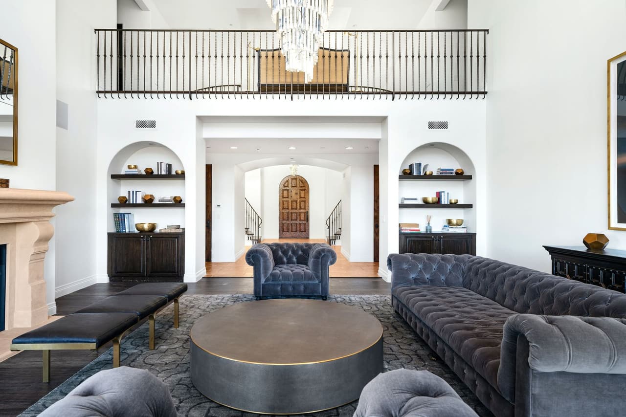 La sala cuenta con chimenea y está decorada con tonalidades grises.