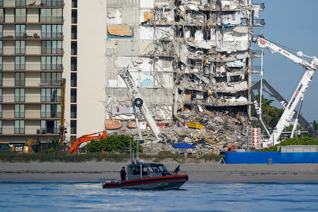 Un barco de la Guardia Costera de EE. UU. Patrulla frente al edificio de condominios Champlain Towers South, parcialmente derrumbado, el jueves 1 de julio de 2021, en Surfside, Florida.