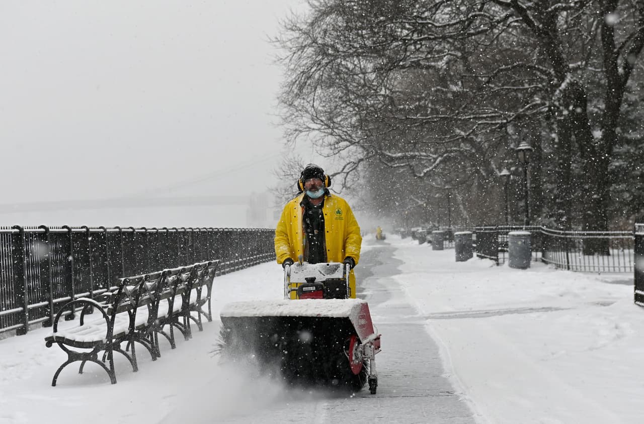 Un hombre utiliza un soplador de nieve durante la nevada.