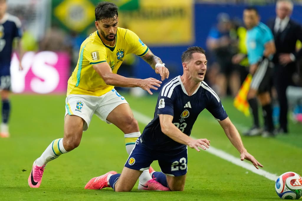 El escocés Kenny McLean reacciona mientras disputa el balón con el brasileño Lucas Paquetá