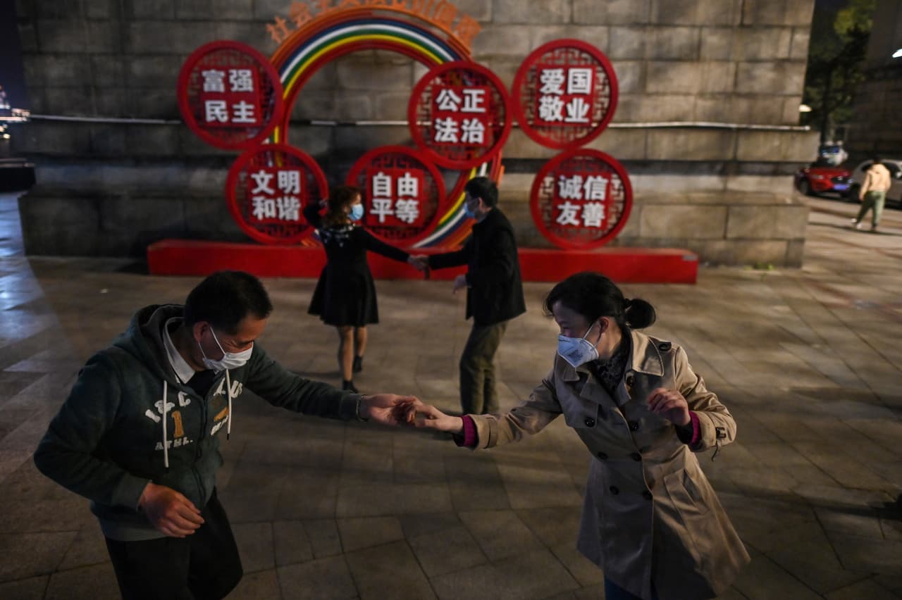 Parejas con mascarillas bailan en un parque junto al río Yangtze en Wuhan el 13 de abril, cuando comenzaban a bajar las restricciones para contener la enfermedad. “La conmoción llegó realmente cuando fuimos a visitar los hospitales rebozados.