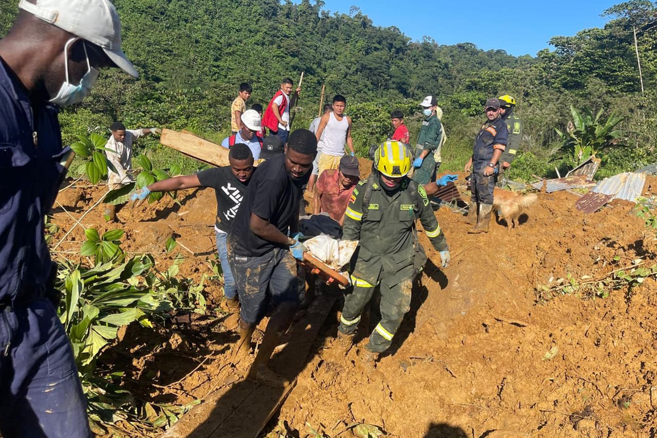 Fotografía cedida por la Policía Nacional de Colombia que muestra a rescatistas y policías mientras trabajan en la recuperación de cuerpos hoy, en el lugar donde ocurrió un derrumbe en inmediaciones del municipio Carmen de Atrato, departamento del Chocó, Colombia.