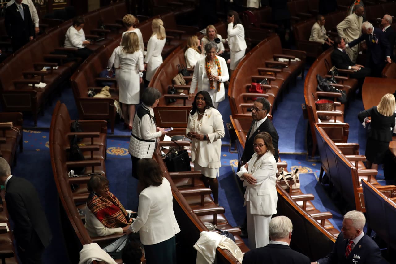 Algunas de las congresistas demócratas, vestidas de blanco, ocupan sus asientos.