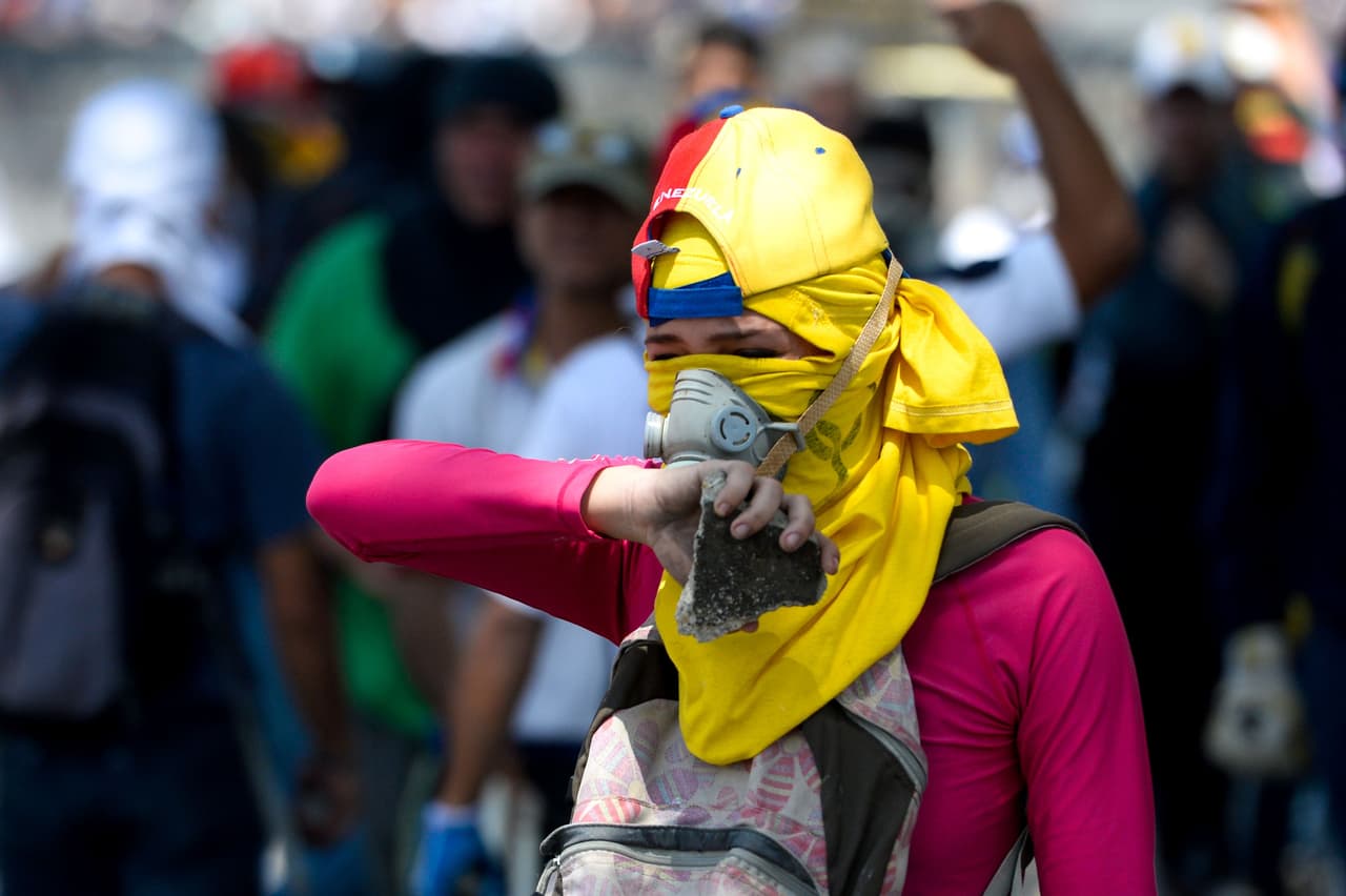 En ocasiones, algunas mujeres también lanzan objetos contundentes contra los agentes represores que impiden el paso con bombas lacrimógenas y perdigones.