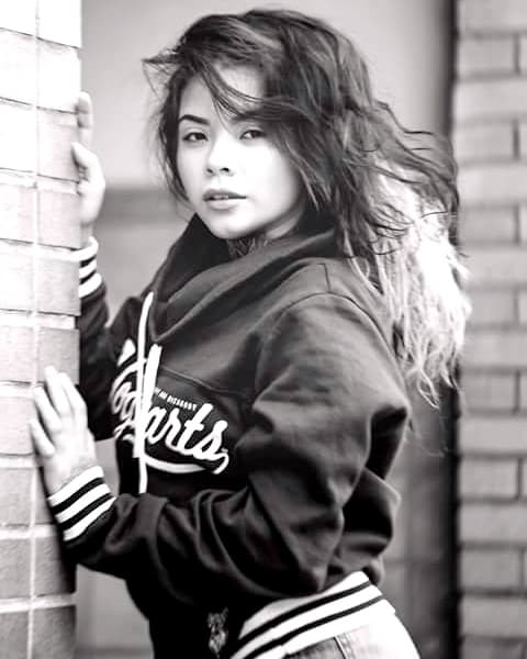 La joven empieza a modelar prendas de vestir.