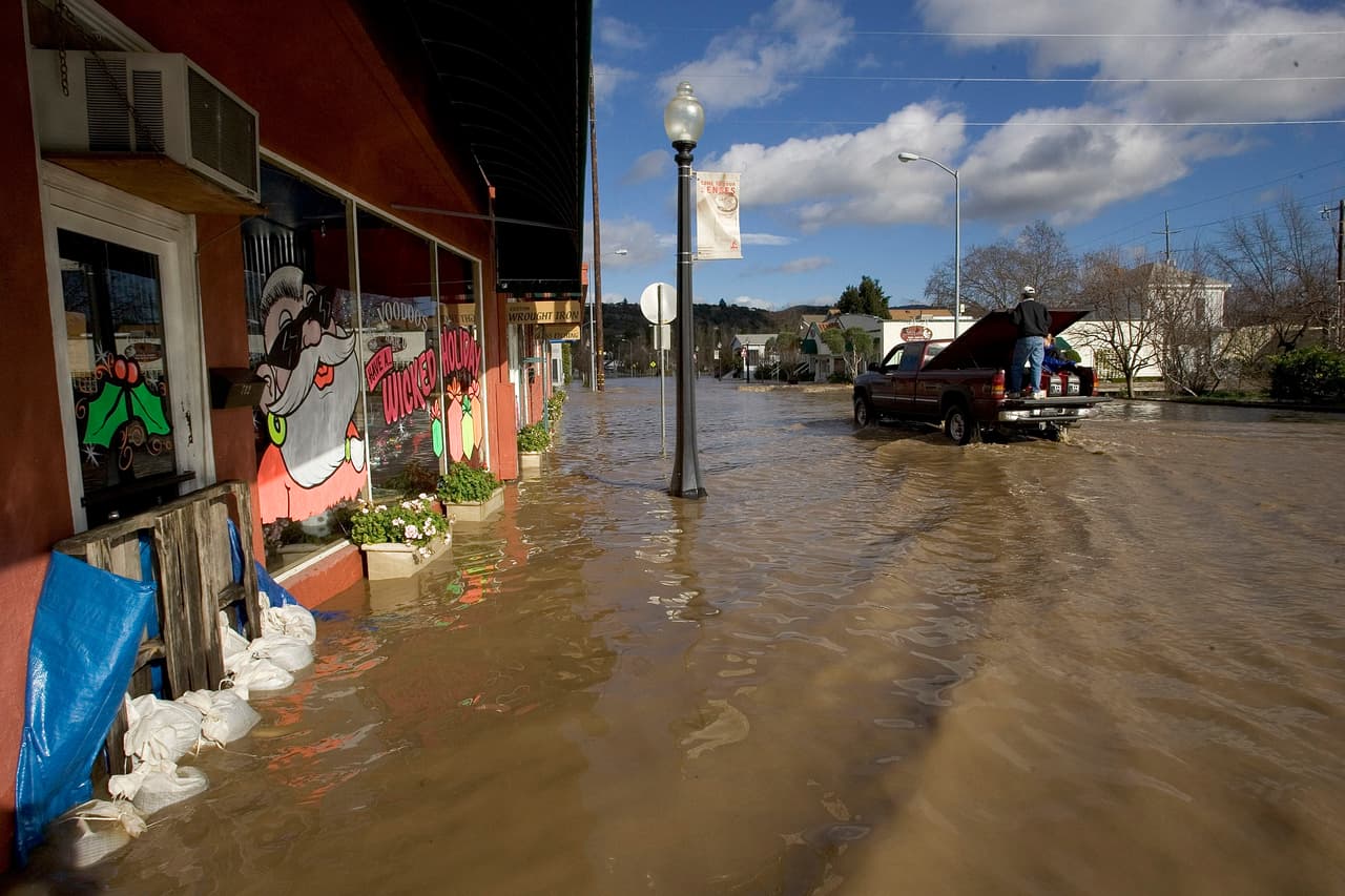 NAPA, CA - DECEMBER 31: A truck drives throught the water as people clean up after a storm left much of downtown under water on December 31, 2005 in Napa, California. A powerful winter storm dumped record amounts of rain and sent rivers and creeks overflowing into many cities and towns in northern California. Forecasters are warning of another storm tomorrow that could set off more flooding and landslides. (Photo by David Paul Morris/Getty Images)