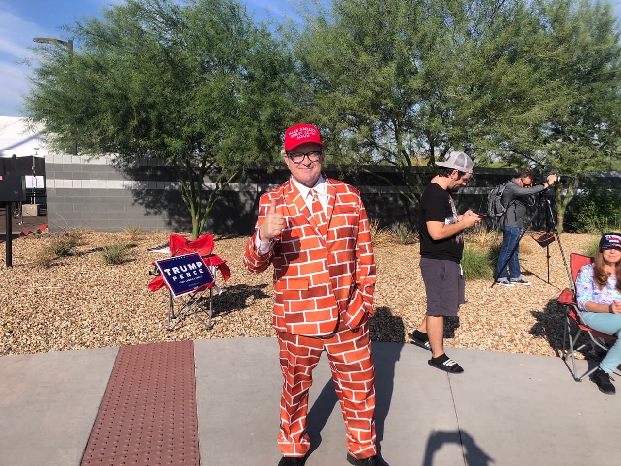 Con un peculiar traje que hace alusión al muro fronterizo con México, este seguidor de Donald Trump apoya la reelección y se hizo presente para escuchar a Pence.