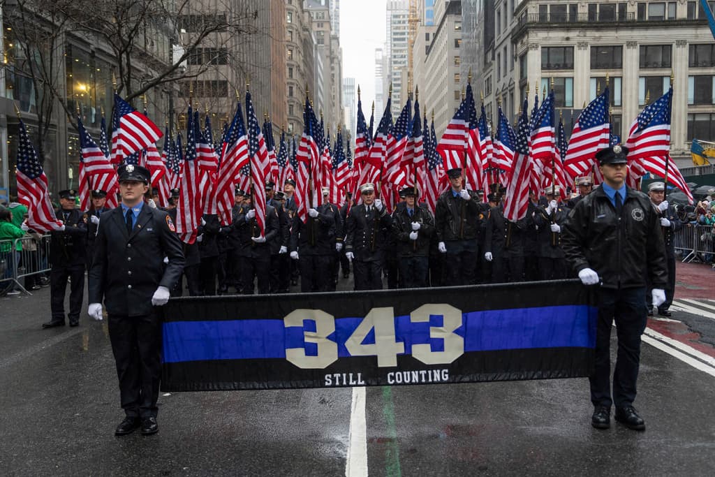 New York Fire Department officers hold flags and a banner for firefighters killed on 9/11 during the 264th New York City Saint Patrick's Day Parade, Monday, March 17, 2025 in New York. (AP Photo/Adam Gray)