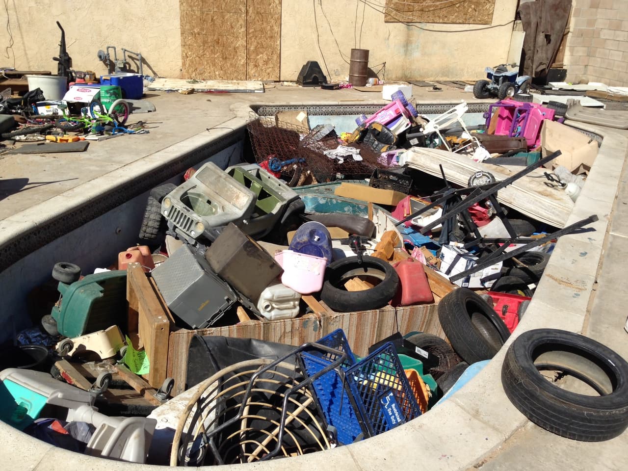 La alberca, algún día quizás llena de agua, ahora lo está de juguetes viejos, llantas, electrodomésticos inservibles, entre otros desperdicios.