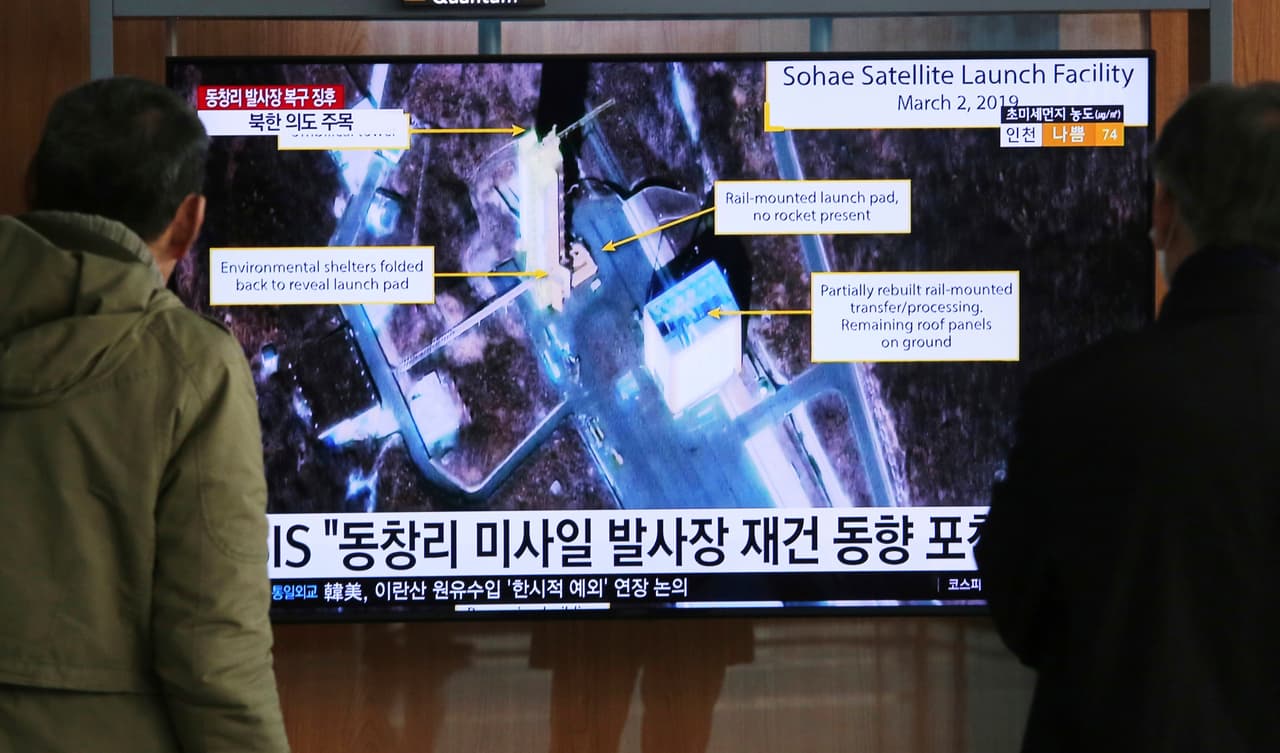 En esta imagen de archivo, tomada el 6 de marzo de 2019, dos personas observan una pantalla que muestra una imagen del Centro de Lanzamiento de Satélites Sohae, en Tongchang-ri, Corea del Norte, durante un noticioso, en la estación de tren de Seúl, en Seúl, Corea del Sur. (AP Foto/Ahn Young-joon, archivo)