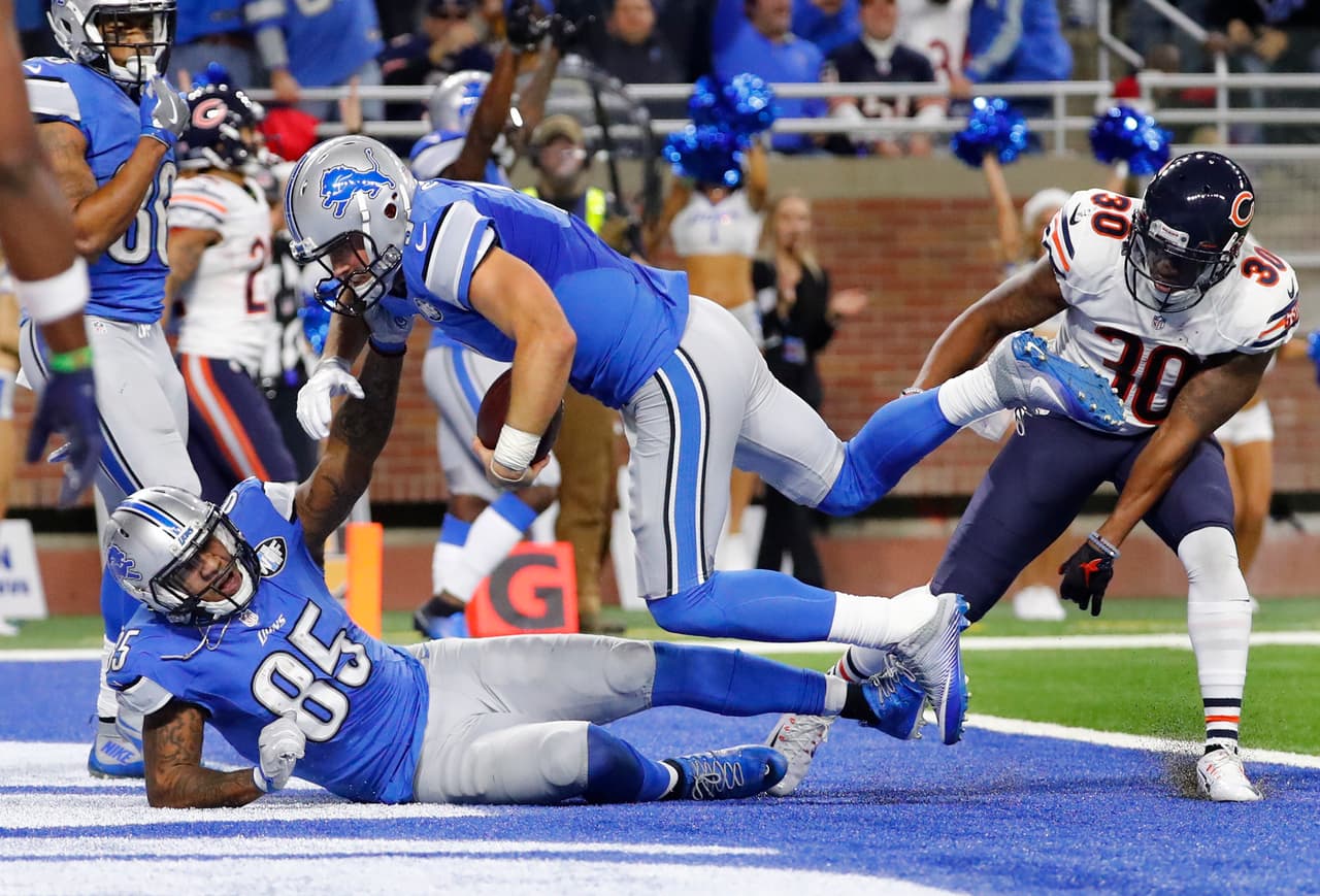 Detroit Lions quarterback Matthew Stafford (9) runs over tight end Eric Ebron (85) for a 7-yard touchdown against the Chicago Bears in the second half of an NFL football game in Detroit, Sunday, Dec. 11, 2016. (AP Photo/Rick Osentoski)