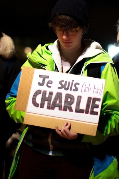 Una persona sostiene un cartel con la frase "Yo soy Charlie" durante una vigilia afuera de la embajada francesa en Berlín, Alemania.