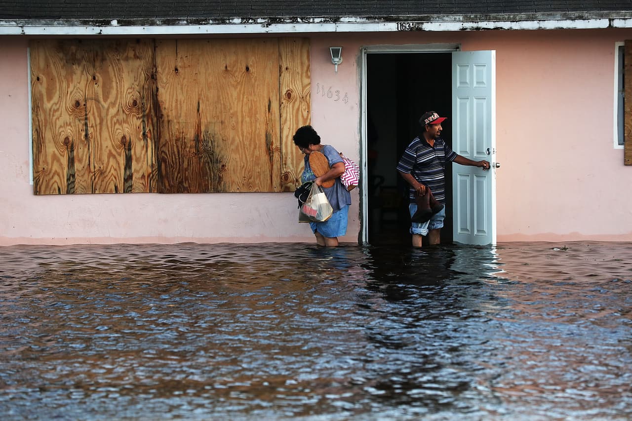 Una pareja deja su hogar inundado en la mañana de este lunes en los alrededores de Fort Myers, Florida.