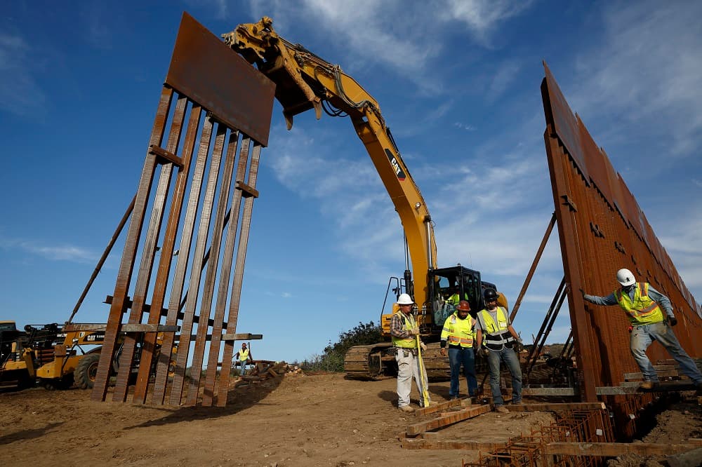 Un equipo de trabajadores reemplaza una parte del muro en en la frontera con Tijuana, California.