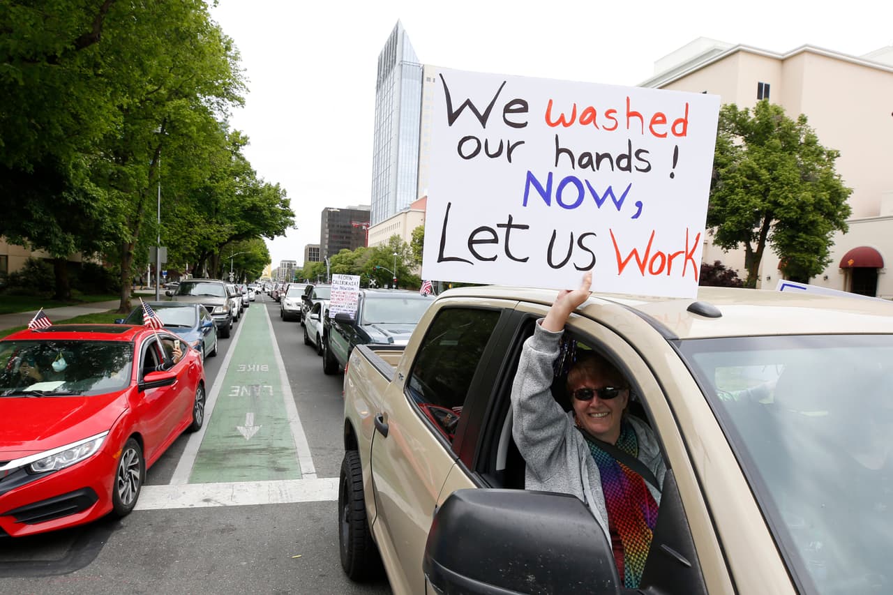 "Nos lavamos las manos, ahora déjanos trabajar", el mensaje de angela Husted desde su camioneta al manejar por la calle Capitol Mall junto con otros manifestantes pidiendo que se levanten las órdenes de quedar en casa. (AP/Rich Pedroncelli)