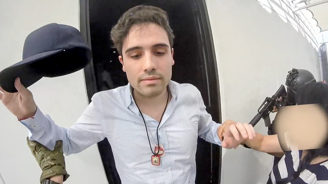 Según detalló el general Luis Cresencio Sandoval, secretario de la Defensa Nacional de México, el operativo contra Ovidio Guzmán López comenzó el 9 de octubre, cuando las fuerzas de intervención salieron de la Ciudad de México hacia Culiacán, Sinaloa. En abril de 2018 una corte federal de EEUU había solicitado la captura con fines de extradición del hijo de Joaquín Guzmán Loera por delitos de asociación delictuosa para distribuir drogas. En la fotografía el momento que
<a href="https://www.univision.com/noticias/narcotrafico/paren-todo-ya-me-entregue-asi-fue-el-fallido-operativo-mostrado-en-video-para-capturar-al-hijo-de-el-chapo">Guzmán López sale al garaje de la casa donde fue sorprendido por las autoridades</a> mexicanas en Culicán el pasado 17 de octubre.