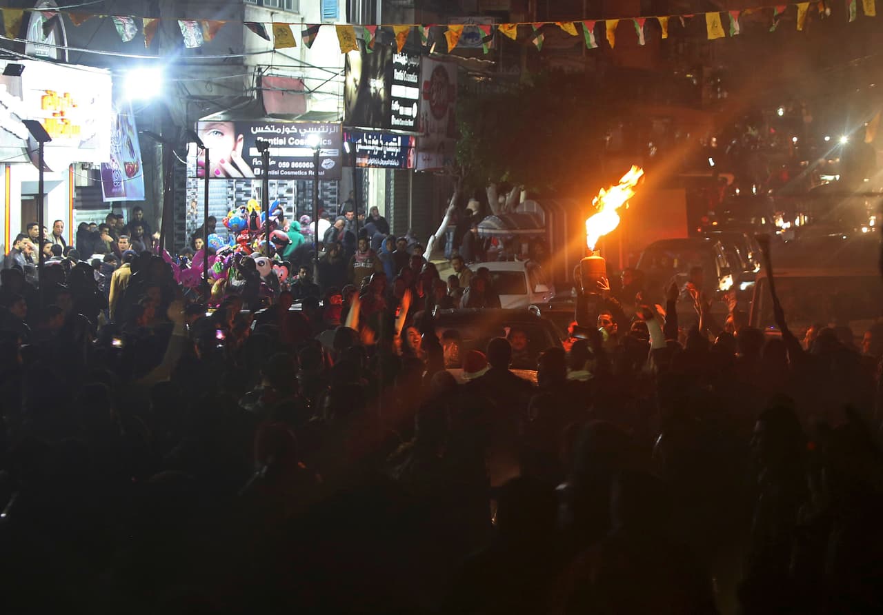 Jóvenes palestinos entonan cánticos en Gaza, mientras encienden llamas con gas para dar la bienvenida al año.