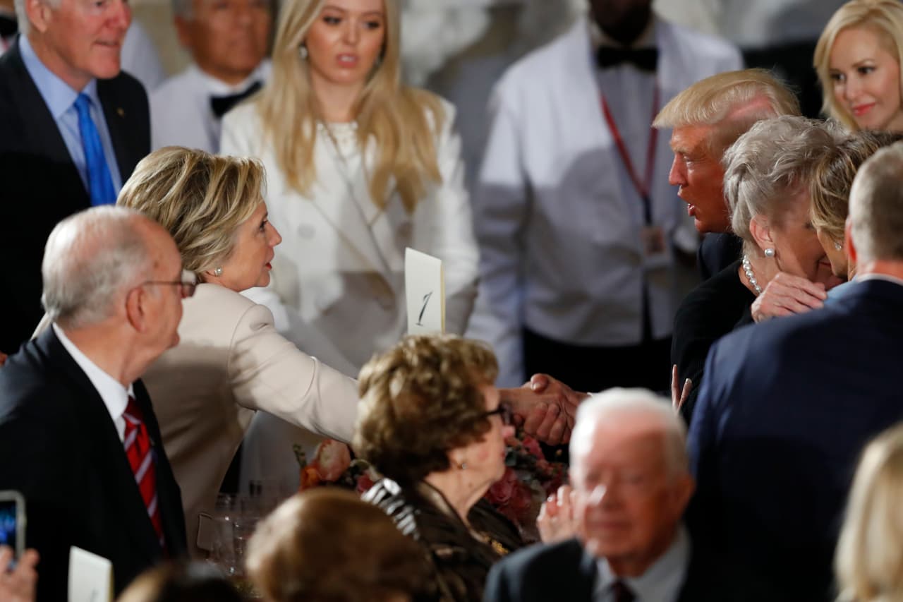 El presidente Trump saluda a su rival en las pasadas elecciones, Hillary Clinton.