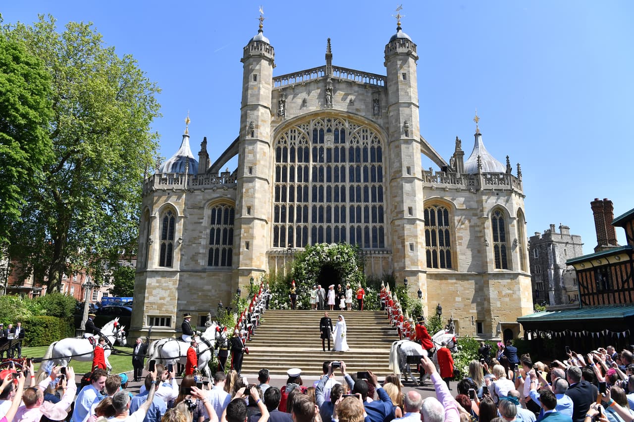 Exterior de la escalinata que da entrada a la capilla de San jorge donde se celebró la misa, en el complejo del castillo de Windsor. Los novios, en el centro, descienden lentamente hacia el carruaje.