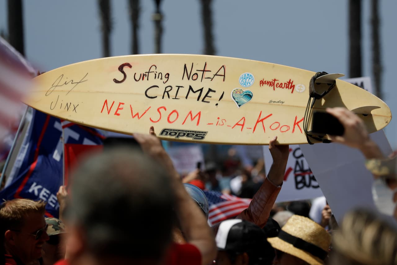 En el sur de California, muchos de las manifestantes marcharon en contra del cierre de las playas en el condado Orange, una semana después de que salieron los residentes en masas y donde no se observaron las reglas de distanciamiento social. (AP Photo/Chris Carlson)