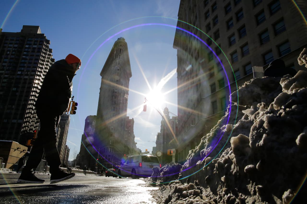 Un hombre camina por la nieve acumulada en la acera cerca del edificio Flatiron en la ciudad de Nueva York.