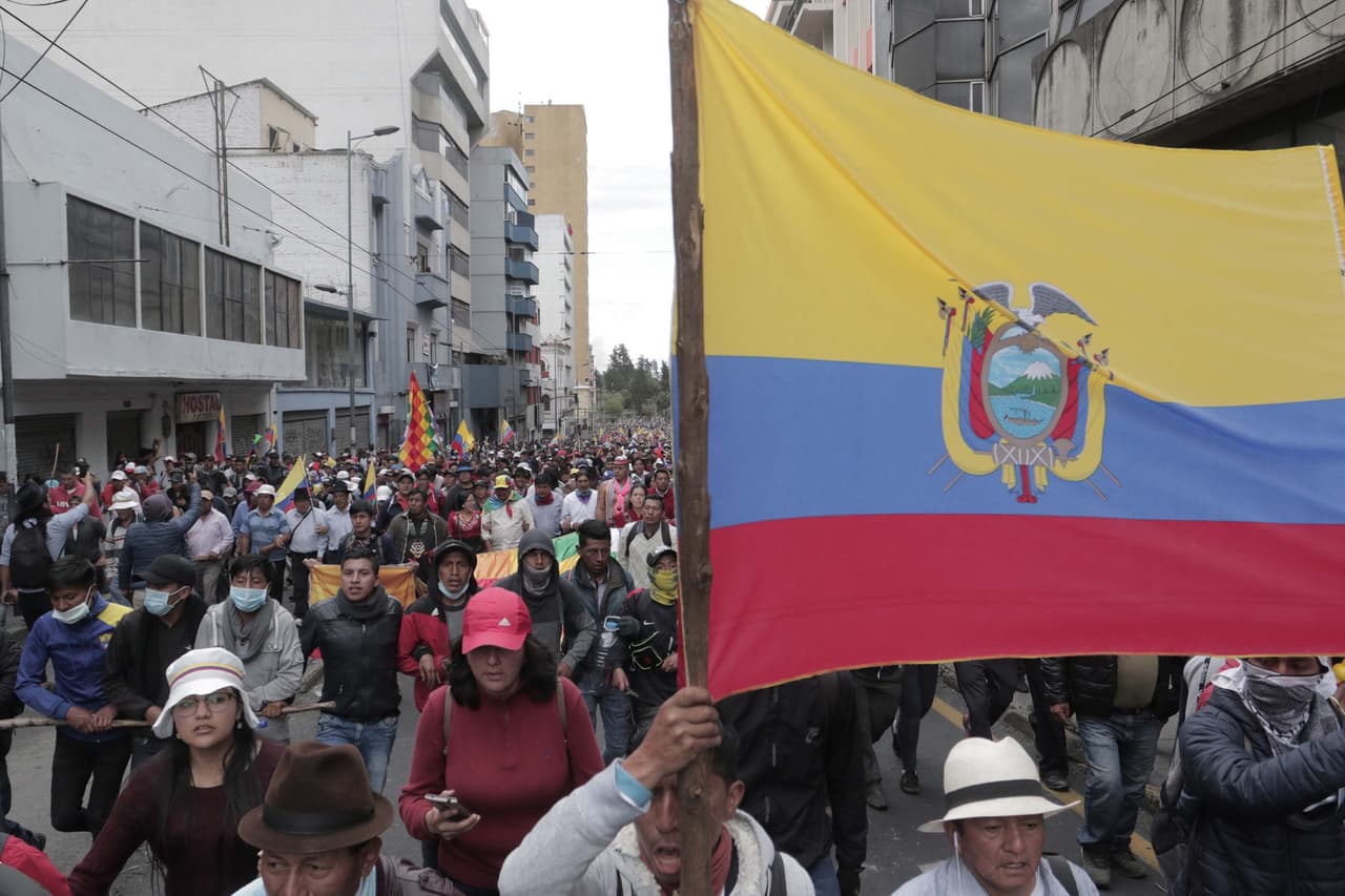 Comunidades indígenas se unen a los manifestantes que sostienen una bandera ecuatoriana cerca del Palacio Presidencial de Carondelet.