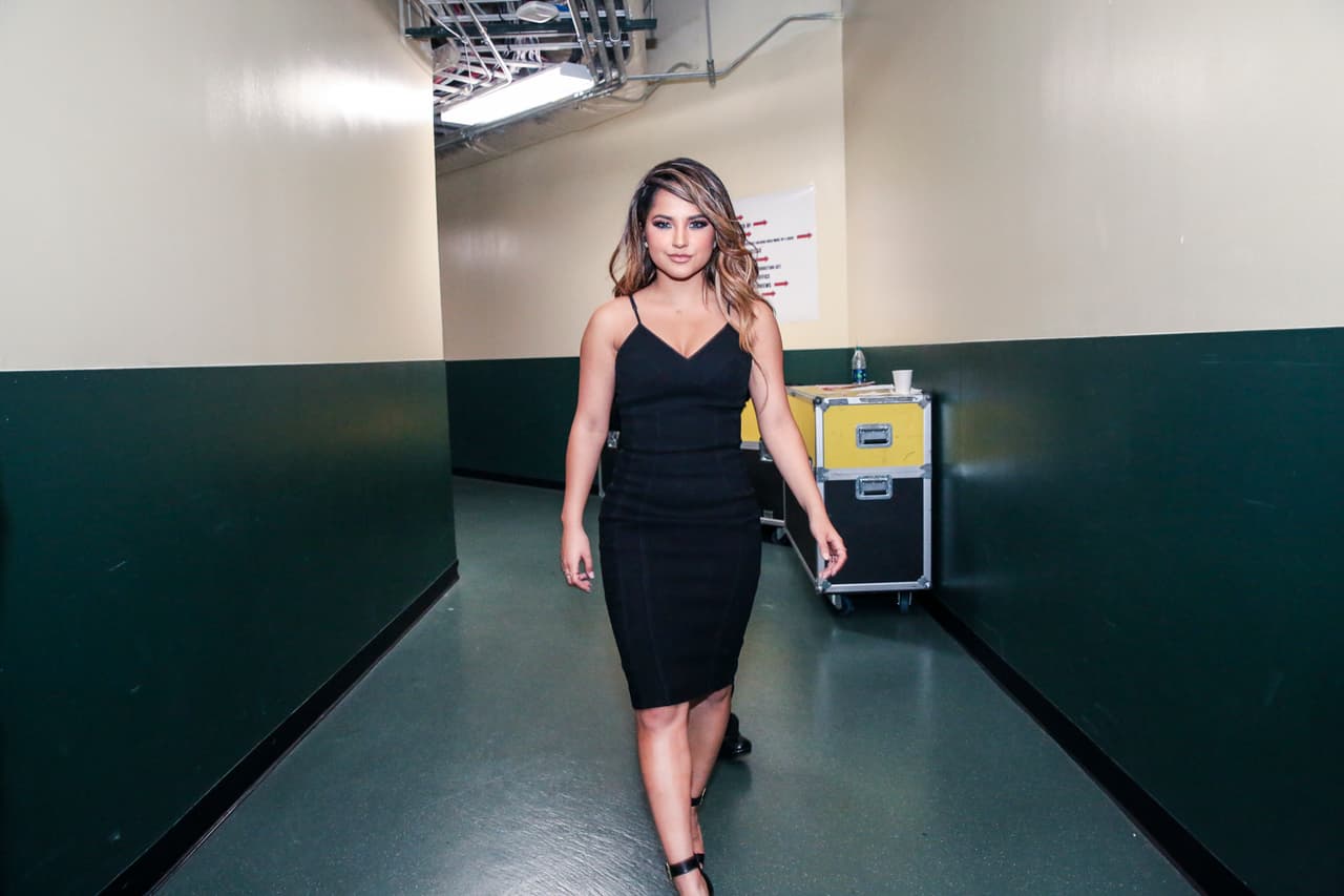 Becky G iba caminando muy solita, pero muy contenta.