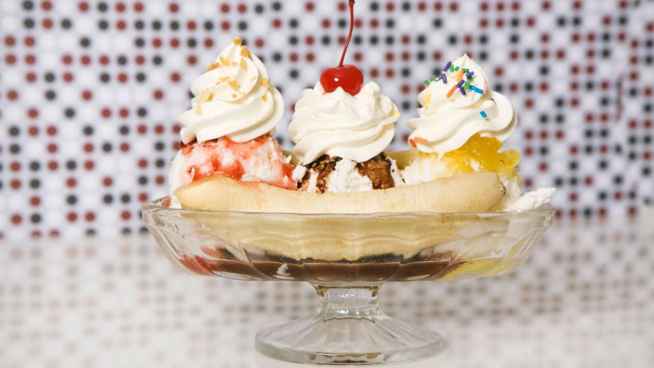 <b>Banana Split</b>: Esta delicia fue inventada por David Strickler en Tassel Pharmacy en Latrobe, Pensilvania, en 1904. Las bananas split se componen de tres bolas de helado de chocolate, vainilla y fresa. Los sabores están rociados con chocolate caliente, fresa y salsa de caramelo. Se cubre con crema batida, nueces picadas, chispas, una cereza y dos mitades de guineo.