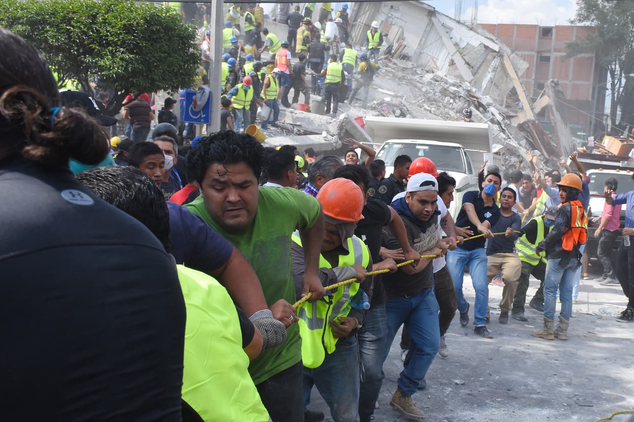 Alrededor de las estructuras colapsadas en la capital mexicana, filas de civiles participan apartando los pesados escombros.