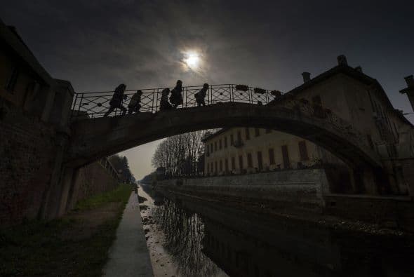 Un grupo de niños cruza un puente en Robecco sul Navigglio, en el este de Milán. Parece una imagen tomada de una película.