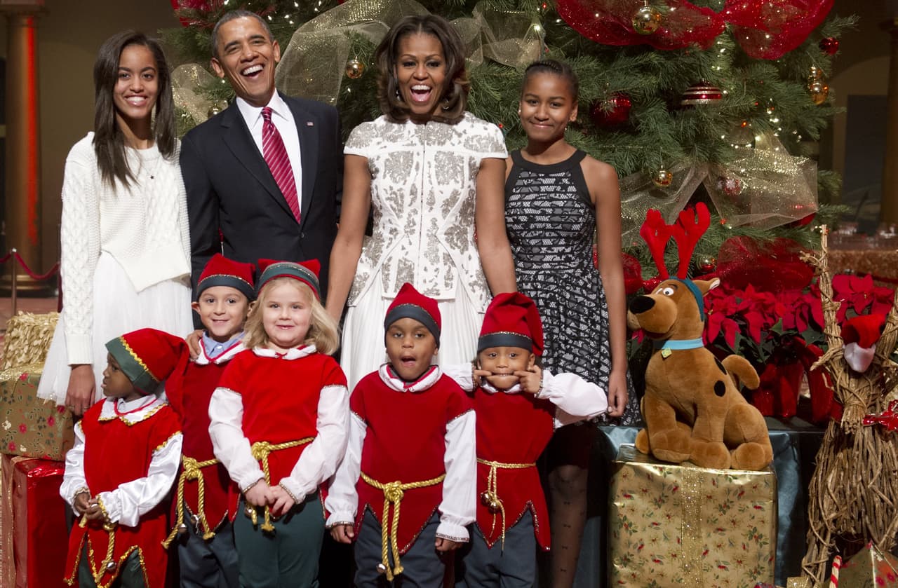 Después de repartir regalos a los niños del 
<i>Children's National Medical Center</i> la familia presidencial se tomó el tradicional retrato con una clara relevancia del color blanco entre los atuendos. Michelle Obama eligió un traje de J. Mendel, de dos piezas con toques de brillos platas en el top, mientras que Malía apostó también por el blanco en un suéter de tejido de punto.