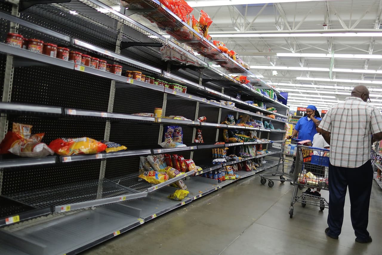 Restos de alimentos y empaques es lo que queda en un pasillo de la sección de alimentos en una tienda Walmart, en Houston, Texas. Harvey se ha intensificado en un huracán y apunta a la costa de Texas con el potencial de hasta 3 pies de lluvia y vientos de 125 mph.