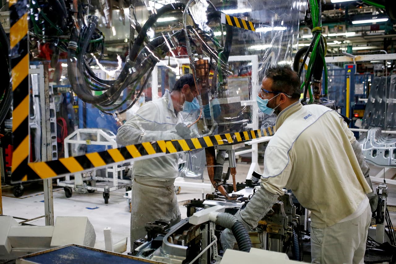Los trabajadores de una planta automotriz en Atessa, Italia, enmascarados y separados por una capa plástica. 27 de abril.