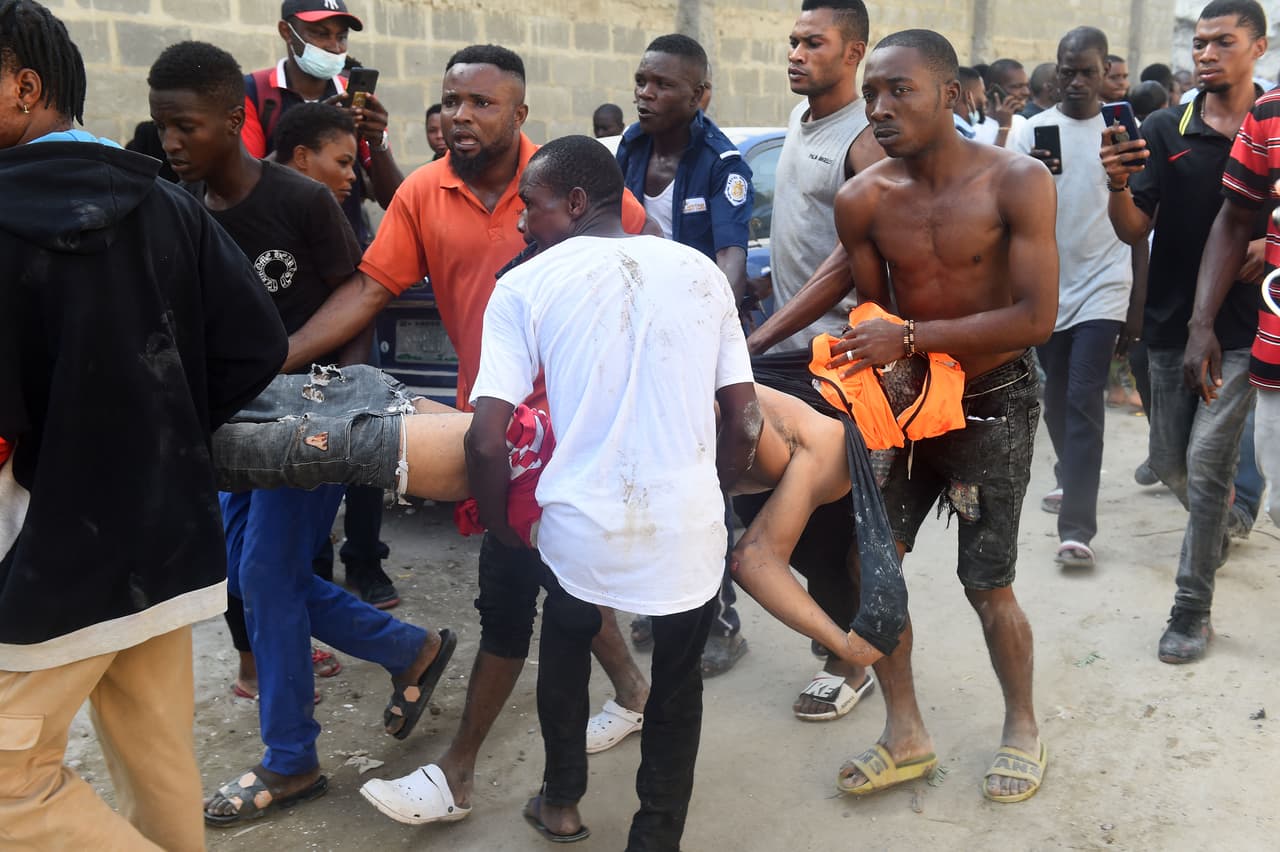 Un grupo de trabajadores carga a uno de sus compañeros fallecidos en el incidente. Antes de la llegada de los cuerpos de rescate excavaban a mano en los escombros junto a otros voluntarios. Más tarde la cruz roja se incorporó a los esfuerzos de rescate.