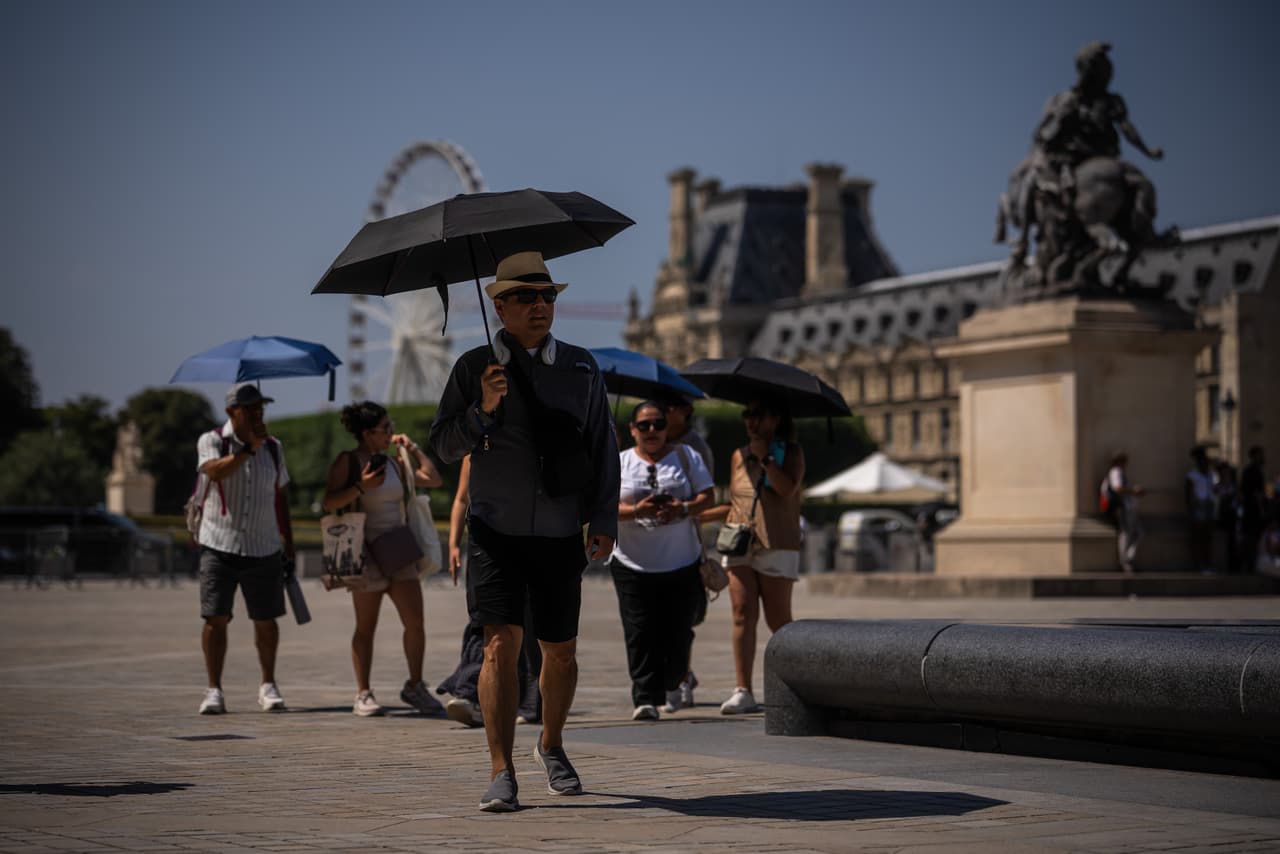 Las plazas de París también se llenan de turistas con sombrillas, para protegerse de los rayos del sol.