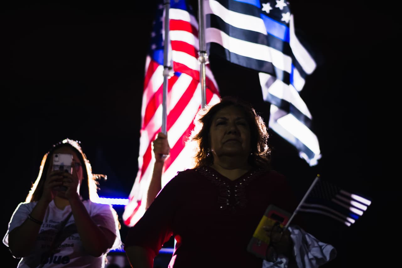 Una mujer lleva una bandera de Estados Unidos y otra que tiene las franjas azules en un mitin de esposas de policías en El Paso, Texas, durante una de las manifestaciones este fin de semana.