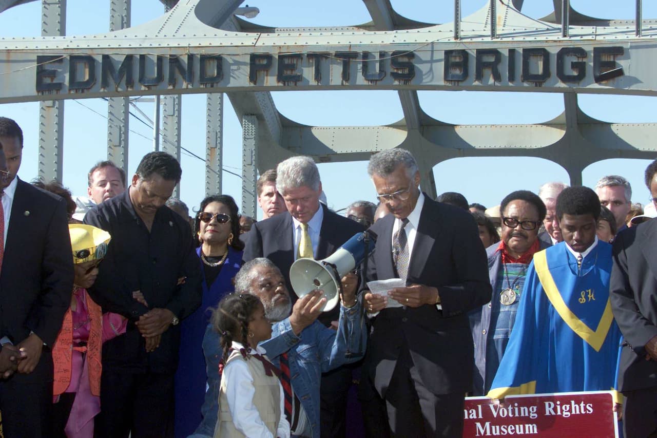 El reverendo C.T. Vivian ofrece una oración junto al ex presidente de los Estados Unidos Bill Clinton, Coretta Scott King y el reverendo Jesse Jackson en el centro del puente Edmund Pettus el 05 de marzo de 2000 en Selma , Alabama, para conmemorar el 35 aniversario de la Marcha por los derechos de voto de 1965.