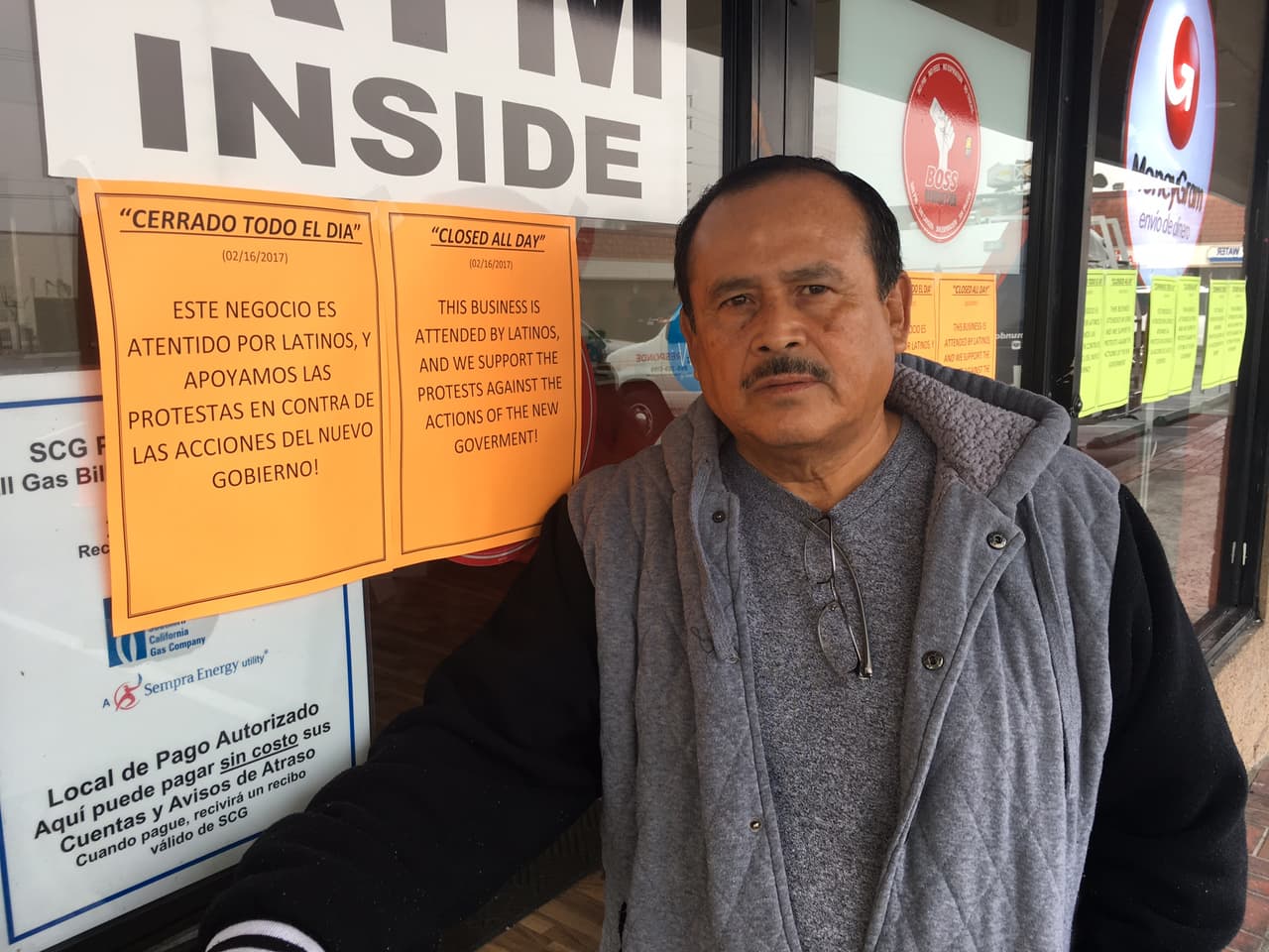 Javier Flores, un albañil que no trabajó en apoyo a la campaña Un día sin inmigrantes, posa frente a un negocio de envío de dinero en Cudahy que cerró por el mismo motivo.