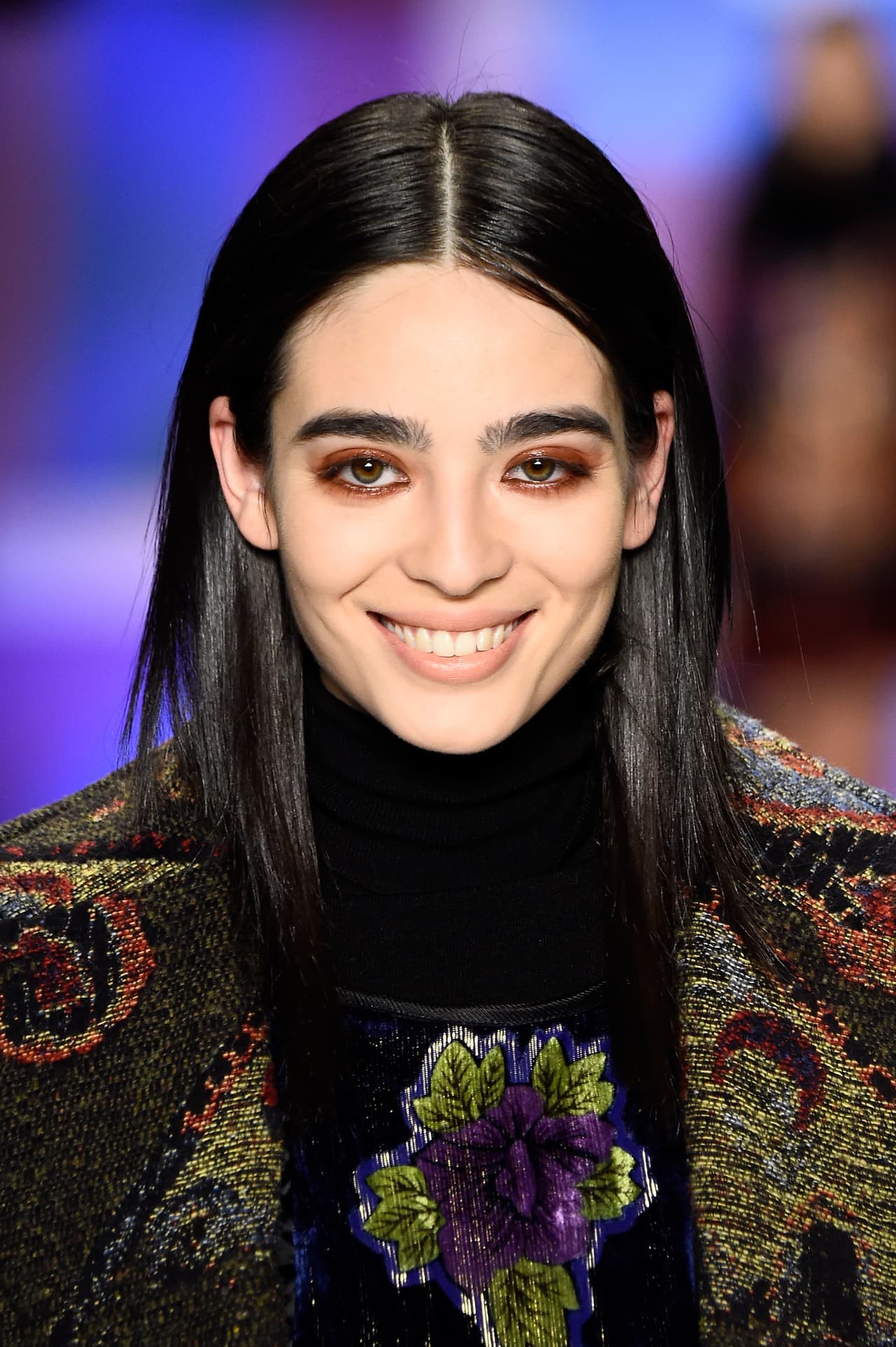 La belleza de las modelos desafía la idea tradicional de lo bello. Se espera de ellas que tengan unos rostros singulares, angulados, con carácter que registren bien en cámara. Aquí, como se lo sugirieron y lejos de lo que es tradicional, Cristina sonríe ante el público.