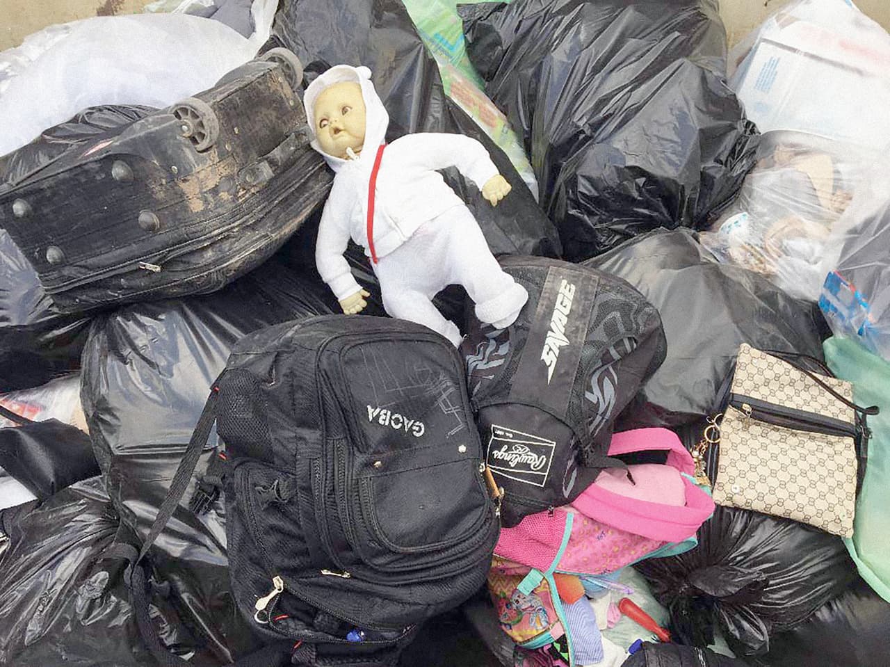 Maletas, carteras e incluso una muñeca en un contenedor. Antes de ingresar al lugar, los inmigrantes deben entregar sus pertenencias a los agentes, que aseguran vienen mojadas, con insectos y moho, por lo que las descartan.