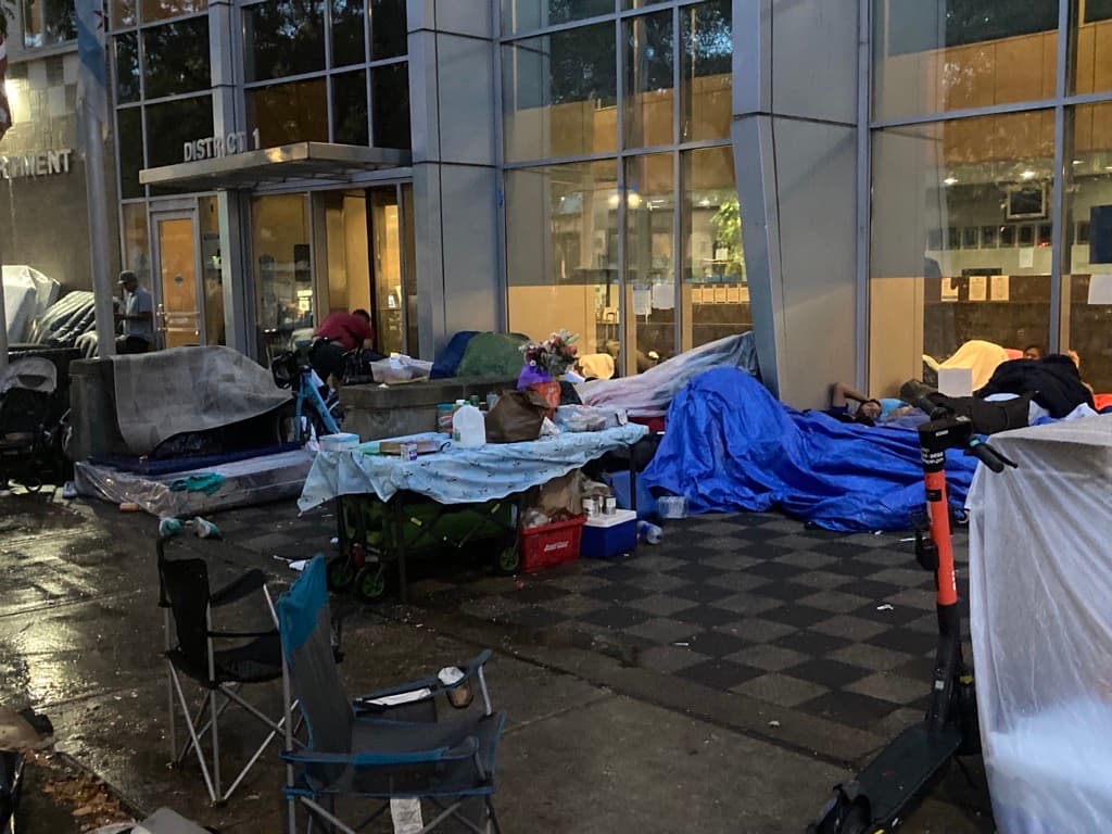 Las pertenencias de migrantes están esparcidas en la calle frente a la estación de la policía del distrito 1.