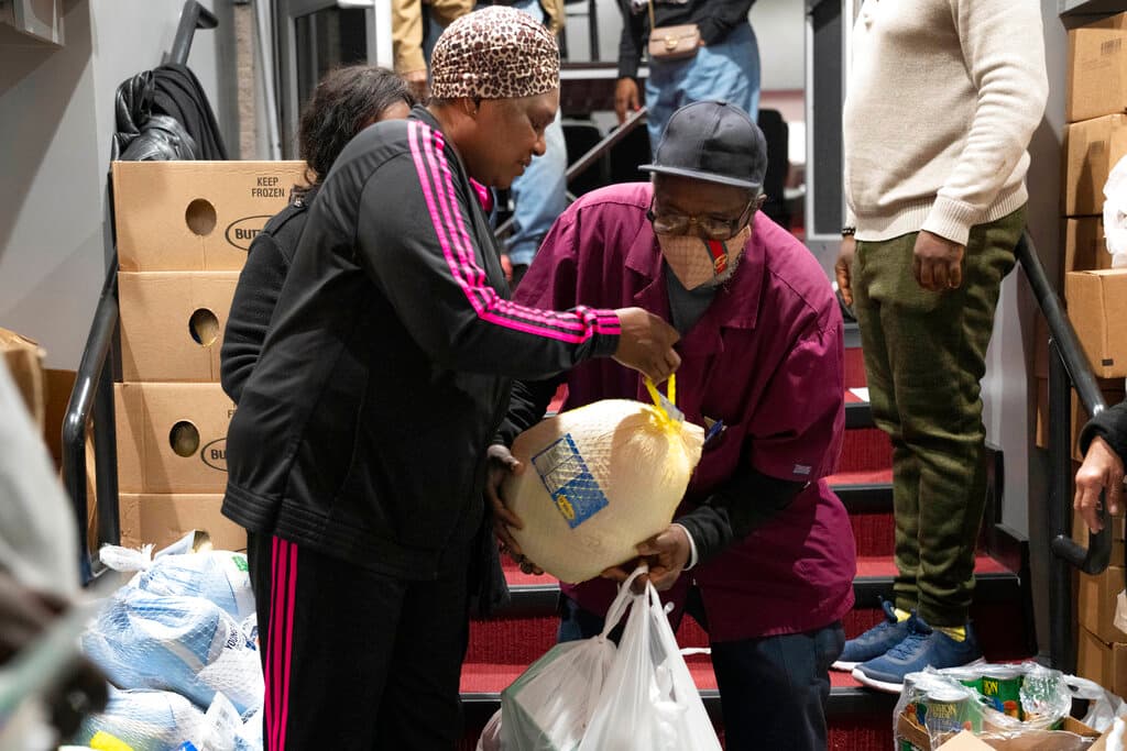 Ricardo Barrett recibe un pavo congelado por Thanksgiving de la iglesia The Redeemed Christian Church of God New Wine Assembly, en Washington.