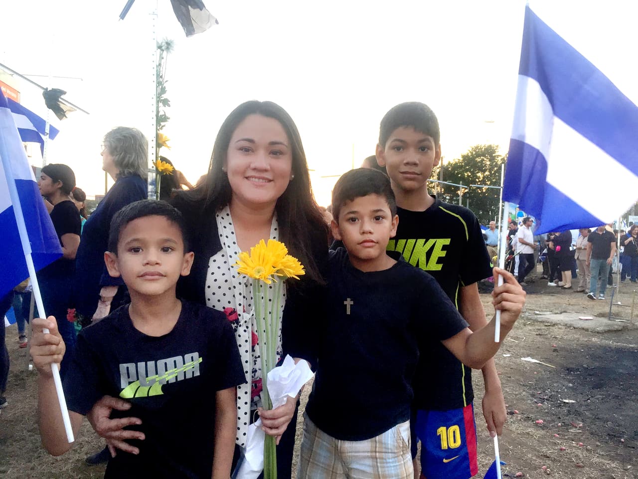 At a vigil for the dead students, Claudia Torres brought flowers with her three children to teach them that "since they are little they can do a lot for their country".